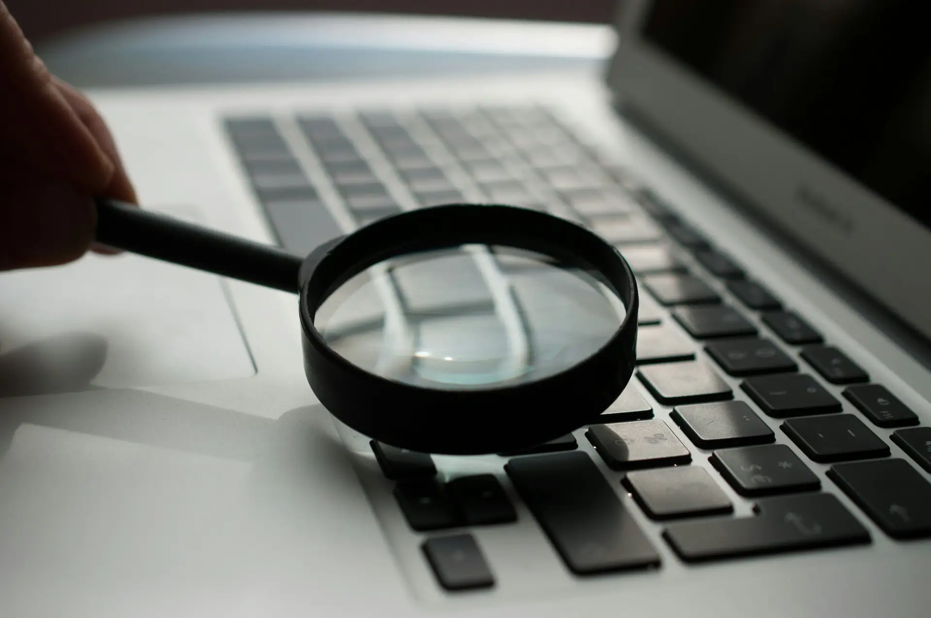 Magnifying glass over laptop - DHML Connect